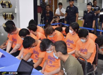 Phone home: Suspected Japanese scammers arrested in Thailand sit at an Immigration Bureau holding center in Bangkok.