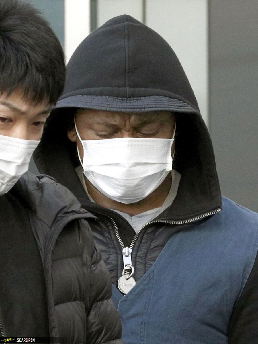 A suspect arrested in a case involving an online romance scam is taken to Fukuoka Prefecture on Tuesday. 