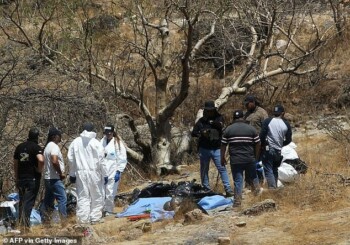 A helicopter extracts bags filled with human remains from the bottom of a ravine in the western Mexico state of Jalisco